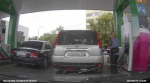 Kobieta myli samochód na stacji benzynowej
