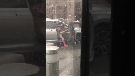 Kobieta na wietrze walczy z drzwiami w samochodzie