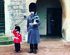 Chłopiec salutuje żołnierzom gwardii zamku Windsor