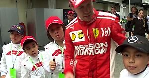 Sebastian Vettel zdziera czapki Mercedesa z głów małych fanów